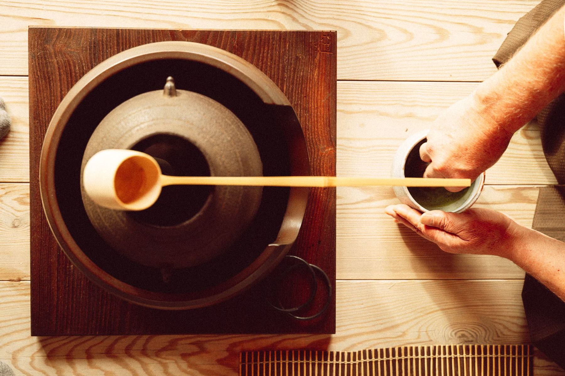 Il matcha versato con il mestolo di bambù durante la cerimonia del tè